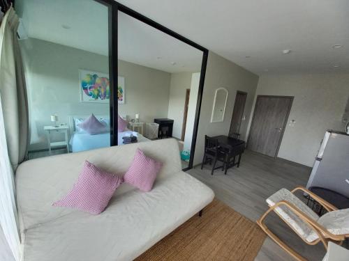 a living room with a white couch with two pink pillows at В7 НОВАЯ КВАРТИРА ВАТСАП669З582I976 можно РУБЛЯМИ in Nai Yang Beach