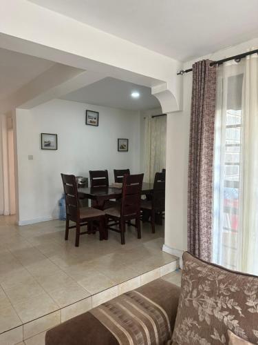 een woonkamer met een eettafel en stoelen bij Arlshy furnished apartments in Kisumu