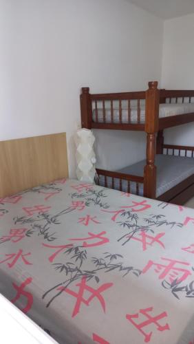 Schlafzimmer mit einem Bett mit roter Schrift in der Unterkunft Apto Guilhermina II in Praia Grande