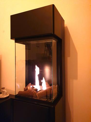 a fireplace with a fire inside of it at Shore Cottage on Valentia Island - Cosy comfort at the sea in Kerry in Valentia Island