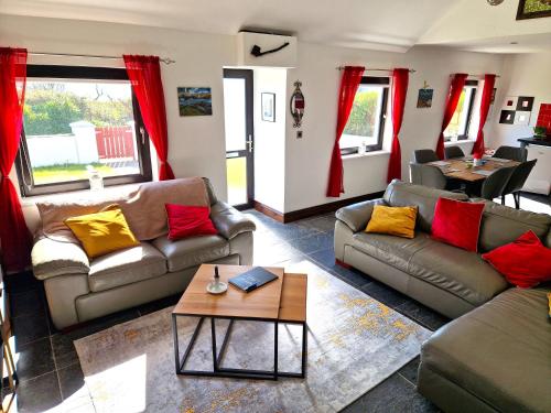 uma sala de estar com sofás e uma mesa em Cosy cottage at the sea em Ilha de Valentia