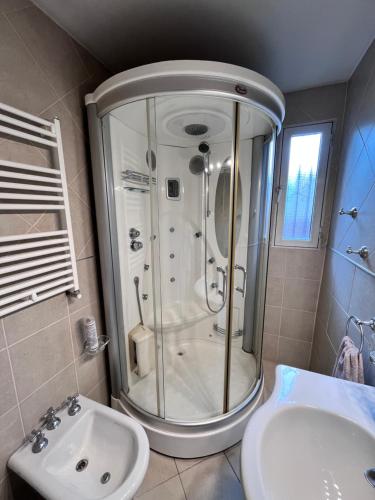 y baño con ducha y lavamanos. en Tierra de Canoeros en Ushuaia