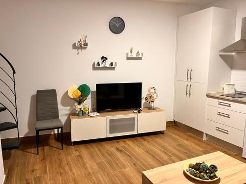 ein Wohnzimmer mit einem TV auf einem weißen Schrank in der Unterkunft Apartamentos EL PELIGRO 1 El CONJURO in Archidona