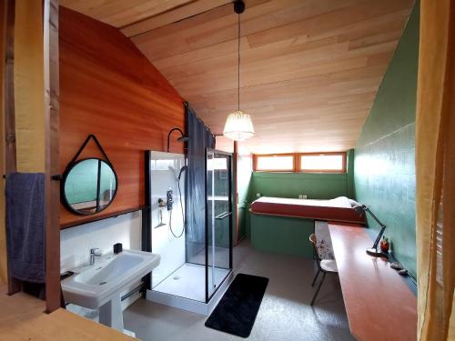 a bathroom with a sink and a toilet and a tub at La Maison des Forges, ancienne grange charentaise transformée en habitation atypique en lisière de forêt pour 15 personnes in Cellefrouin