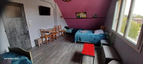 1 dormitorio con 1 cama, mesa y sillas en Les Trois chambres de LYLY situées a Brou, en Brou