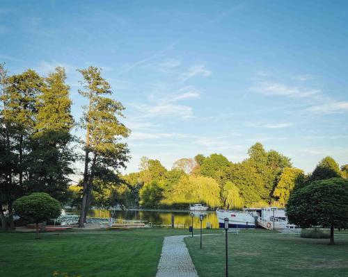 a park with a lake and boats in the grass at DAS SCHMÖCKWITZ in Berlin