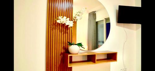 a bathroom with a mirror and a vase on a shelf at Chez Charifa in Asilah