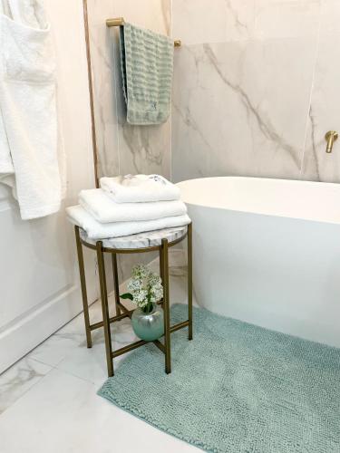 a bathroom with a bath tub and a table with towels at Private Apartment at Ocean View Villas in Port Edward