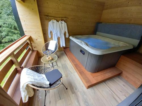 a sauna with a tub and a table and chairs at L'Echappée Magique in Mandray