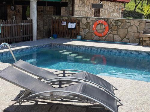 uma piscina com uma cadeira reclinável ao lado de uma piscina em Casa Apartamento Rural U Penafrol em Eljas