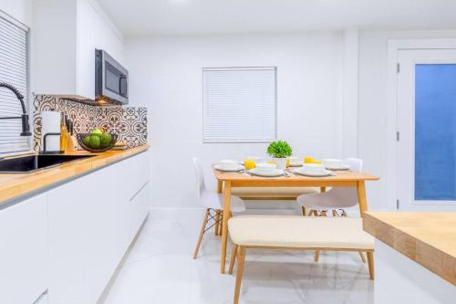 a kitchen with a wooden table and chairs in a room at Serenity Lodge II Condo in Miami