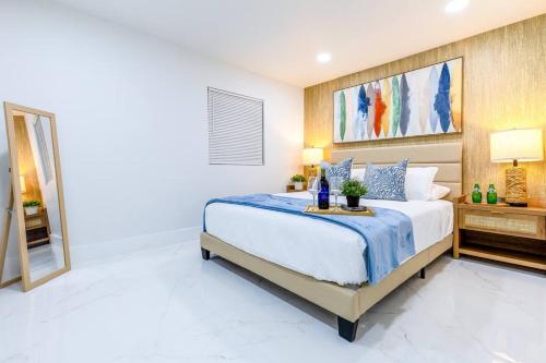 1 dormitorio con 1 cama grande y espejo en Serenity Lodge II Condo en Miami