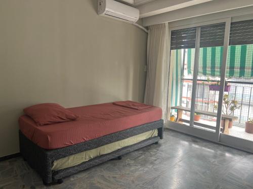 Un dormitorio con una cama y una ventana grande. en HERMOSO DEPTO. EN PLENO PALERMO SOHO, en Buenos Aires
