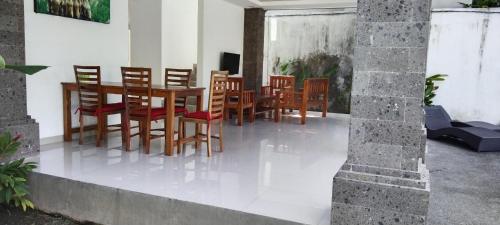 une salle à manger avec des chaises en bois et une table dans l'établissement purnama fullmoon resort, à Ubud