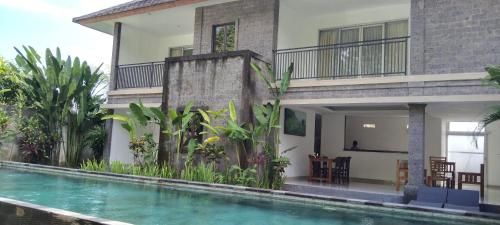 a house with a swimming pool in front of a house at purnama fullmoon resort in Ubud