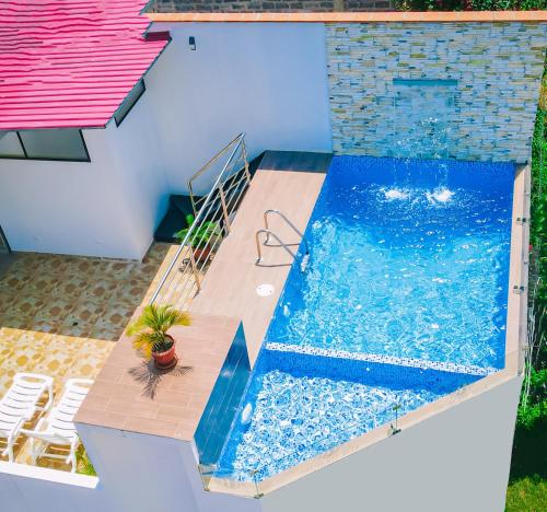 - une piscine avec une plante en pot à côté d'une maison dans l'établissement Real Tarapoto, à Tarapoto