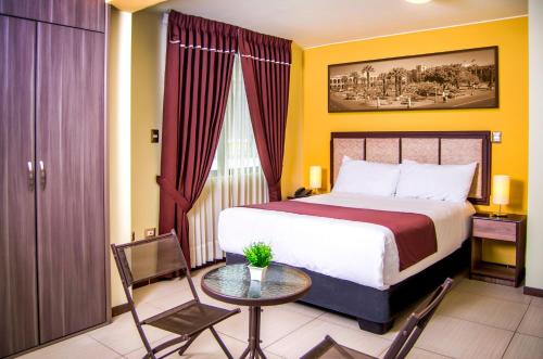 Habitación de hotel con cama, mesa y sillas en Hotel D'Carlo Class, en Arequipa