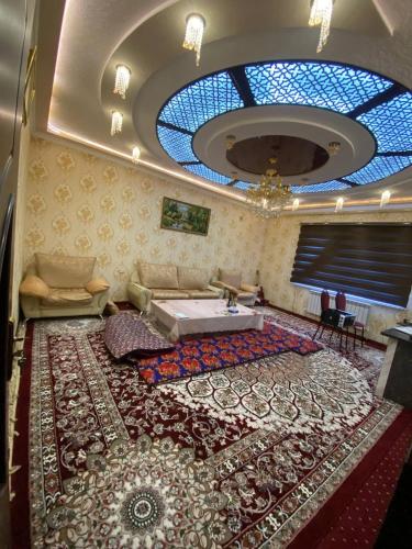 ein Wohnzimmer mit einem großen Teppich auf dem Boden in der Unterkunft Апартаменть in Jizzax