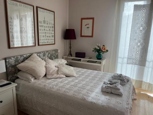 um quarto com uma cama branca com almofadas e uma janela em B&B La Mammola em Lugo