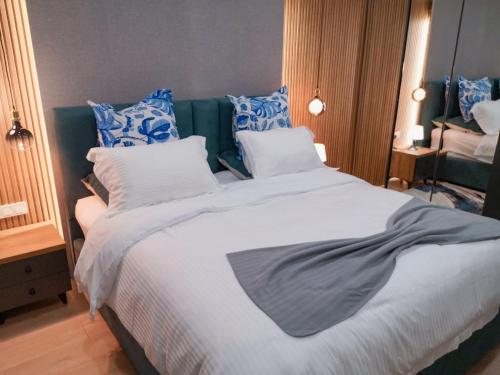 a bedroom with a large bed with blue and white pillows at Gudauri Travel Chalets in New Gudauri in Gudauri