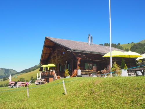 a log cabin with yellow umbrellas in a field at Chalet Chanso in Morgins