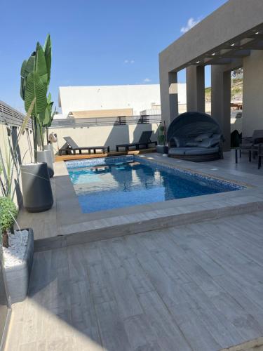 een zwembad bovenop een huis bij וילת צאלים in Yeroẖam