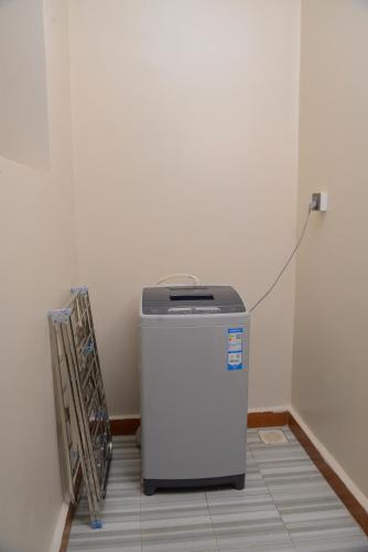 a small refrigerator sitting in a room next to a wall at Entebbes Trendy 3 Bedroom Suite in Namulanda