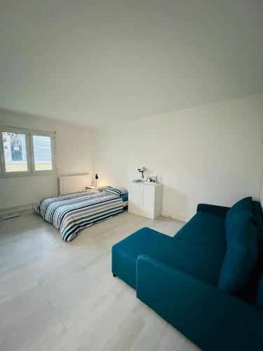 uma sala de estar com um sofá azul e uma cama em Private Room Near Paris em Montreuil
