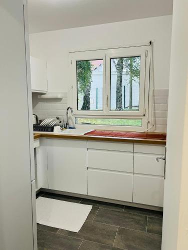 uma cozinha com armários brancos e uma janela em Private Room Near Paris em Montreuil