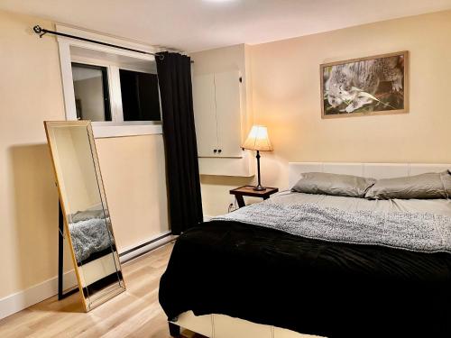 a bedroom with a bed and a mirror at Cozy Newly built apartment airport location in Dieppe