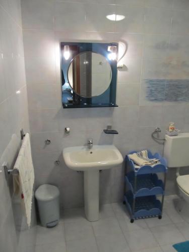 a bathroom with a sink and a mirror and a toilet at Apartments Ruby in Funtana