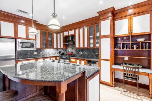 a kitchen with wooden cabinets and a large island at Ski In/Ski Out Luxury Tremblant Chalet in Mont-Tremblant