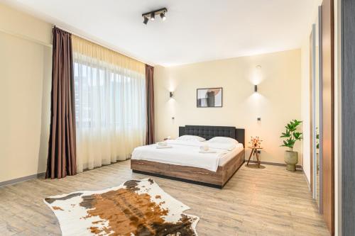 - une chambre avec un lit et une grande fenêtre dans l'établissement B41 Apartment Poiana Brasov, à Poiana Brasov