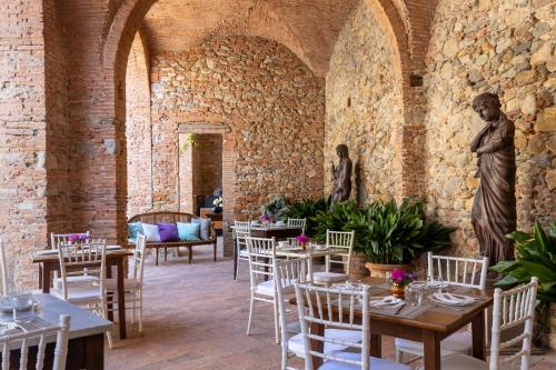 un comedor con mesas y sillas y una estatua en Villa Scorzi - Relais de Charme, en Calci