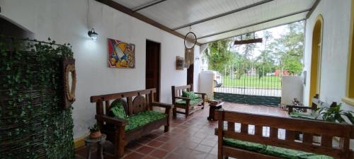a porch with benches and a view of a yard at Pousada e Restaurante Dona Siroba in Morretes