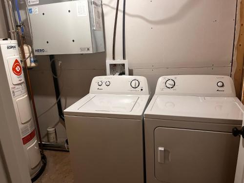 two washing machines sitting next to each other in a room at Cozy Newly built apartment airport location in Dieppe