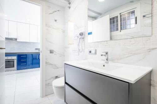 een witte badkamer met een wastafel en een toilet bij Don Paco 12-B Deluxe Apartment Levante Beach in Benidorm