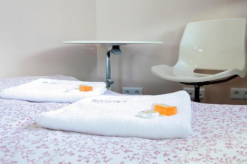 a bed with two towels and a table on it at P&O Serviced Apartments GDANSKI STATION in Warsaw