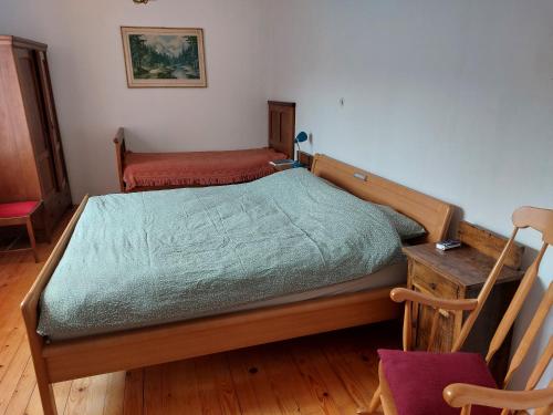 a bedroom with a bed and a table and a chair at Domačija pri Ivankovih in Osilnica