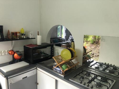a kitchen with a stove and a counter top at Location Villa pleine Nature Domaine des Radiers in Sainte-Rose