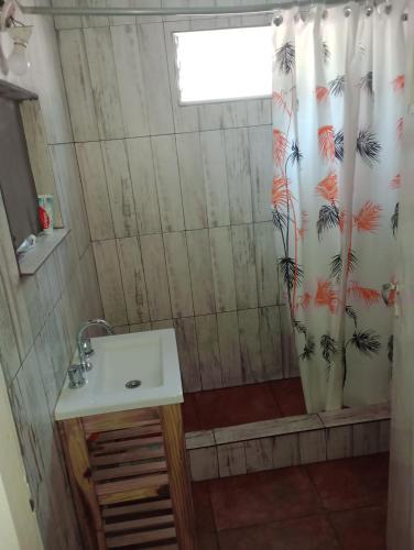 a bathroom with a sink and a shower curtain at Il Giardino de Santa in Santa Teresita