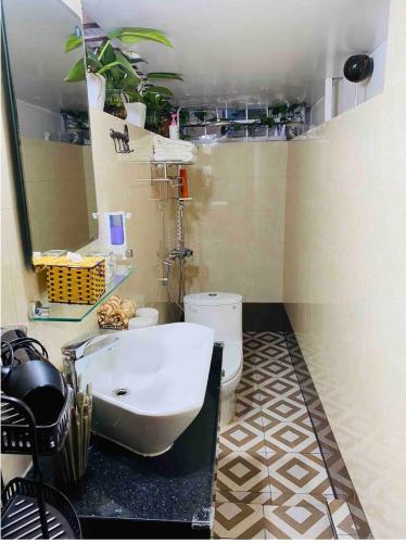 uma casa de banho com um lavatório branco e um WC. em Home stay doctor 23 em Hanói