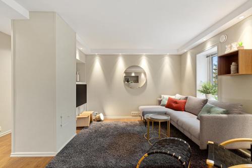 ein Wohnzimmer mit einem Sofa und einem Tisch in der Unterkunft Cozy elegant 2bedroom apt w/parking and nice view in Tromsø