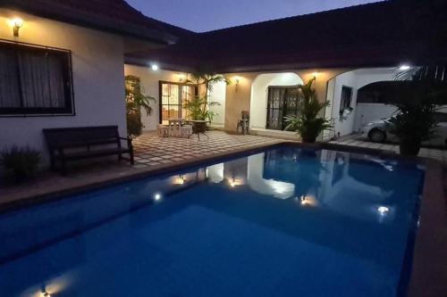 a swimming pool in front of a house at night at Detached 3 bed Villa, private pool - Nirvana Pool Villa 2 in Nong Prue
