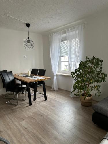 una sala da pranzo con tavolo, sedie e finestra di Gemütliche Wohnung in zentraler Lage a Graz
