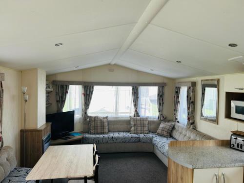 a living room with a couch and a tv at Cherry Tree 14, Lyons Robin Hood Park in Rhyl