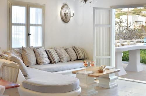 a living room with a couch and a table at Villa Mon Rêve "5-minute walk beach, restaurants, supermarket" in Mýkonos City