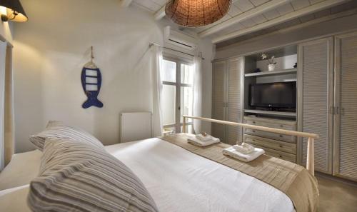 a bedroom with a bed and a television in it at Villa Mon Rêve "5-minute walk beach, restaurants, supermarket" in Mýkonos City