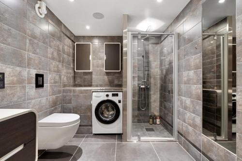 łazienka z pralką i prysznicem w obiekcie Cozy elegant 2bedroom apt w/parking and nice view w mieście Tromsø