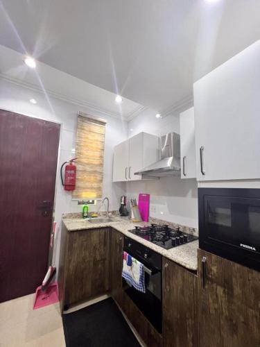 a kitchen with white cabinets and a stove top oven at Patrick Court in Lagos